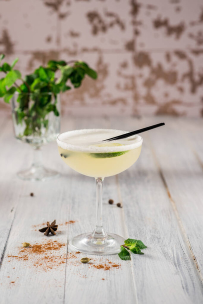 An alcohol cocktail with lime in glass on white background - Fotó, kép