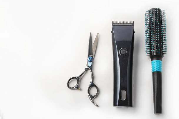 Schere, Haarschneidemaschine und Kamm auf weißem Hintergrund. - Foto, Bild