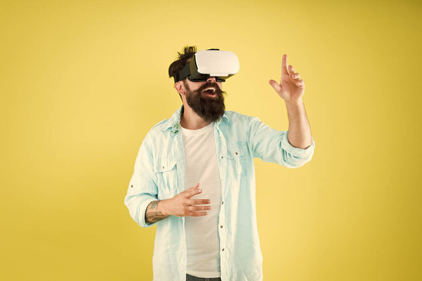 Large selection of compatible apps. Vr concept. Buy vr device. Eye tracking. Testing software. Bearded man yellow background vr glasses. Digital future and innovation. Developing technologies - Φωτογραφία, εικόνα