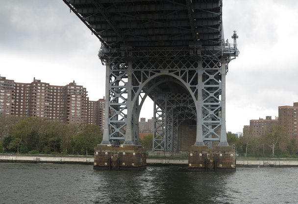 κάτω γέφυρα χάλυβα στήριξης της γέφυρας του Μανχάταν με γκρίζο ουρανό και διαμερίσματα στο παρασκήνιο - Φωτογραφία, εικόνα