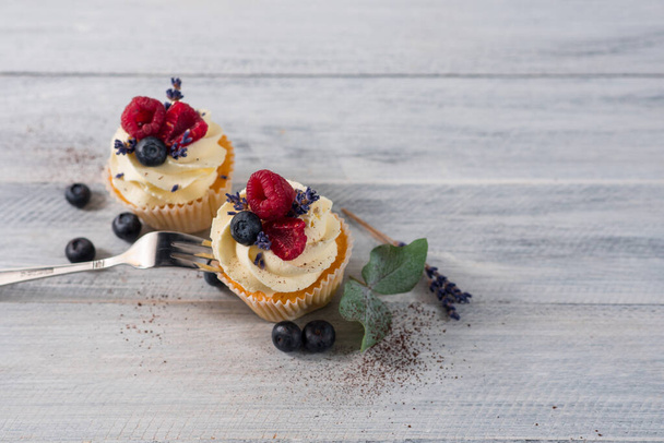 Sweet dessert cupcakes with fruits on the white wooden background - Foto, immagini