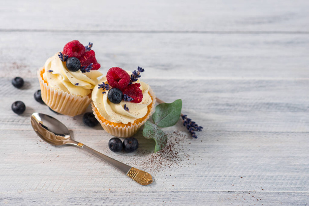 Sweet dessert cupcakes with fruits on the white wooden background - Photo, Image