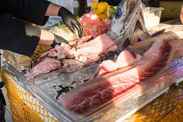 A cook cuts a big fish to a pieces in restaurant - Foto, Bild