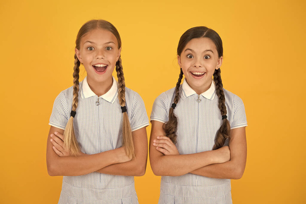 Χαρούμενα μαθήτριες κίτρινο φόντο. Κοριτσάκια. Ευτυχισμένα παιδικά μέρα. Ισότιμη προστασία των ατομικών δικαιωμάτων και ελευθερία από τις διακρίσεις. Τέλεια μαθήτριες. Μαθήτριες vintage απλό ντύσιμο στυλ - Φωτογραφία, εικόνα