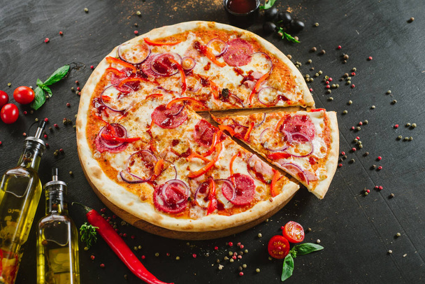 Delicious classic meat pizza on black background - Фото, изображение
