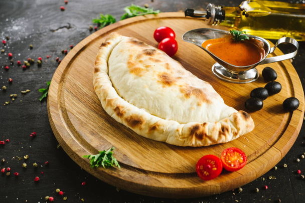 Tasty lavash pie with meat and vegetables on black - Фото, изображение