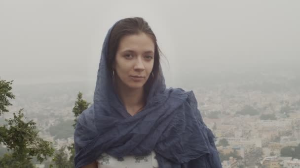 Portrait of natural girl on foggy urban panoramic landscape outdoors text space. Tranquil woman looking calm posing on indian city pan view slow motion. Female beauty products natural cosmetics - Footage, Video