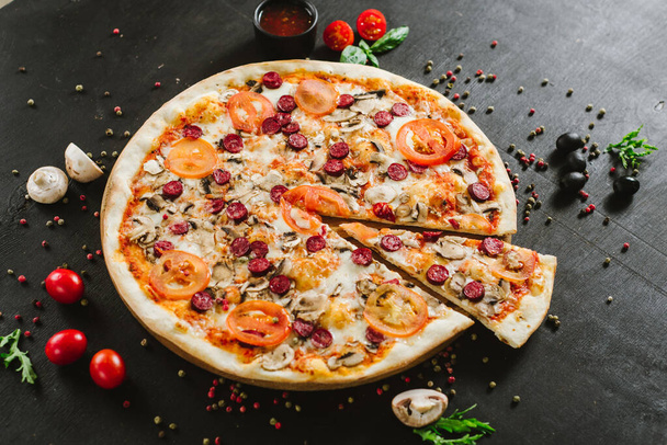 Tasty meat pizza with various ingredients on black background - Foto, Imagem