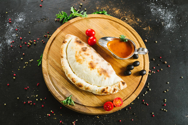 Tasty lavash pie with meat and vegetables on black - Foto, Bild