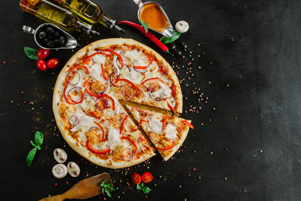 Pizza woth onion and pepper on black background - 写真・画像