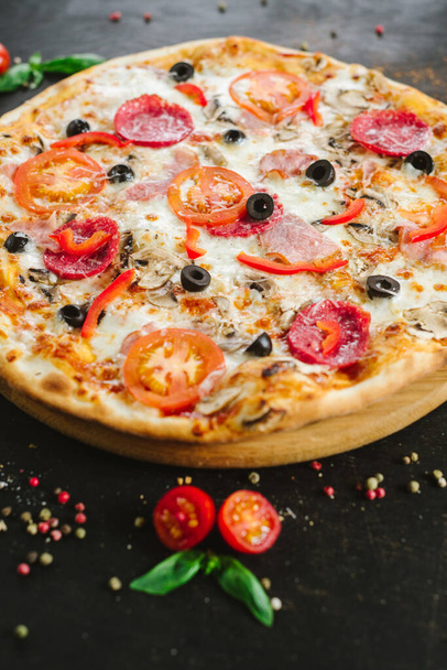 Delicious classic meat pizza on black background - Foto, imagen