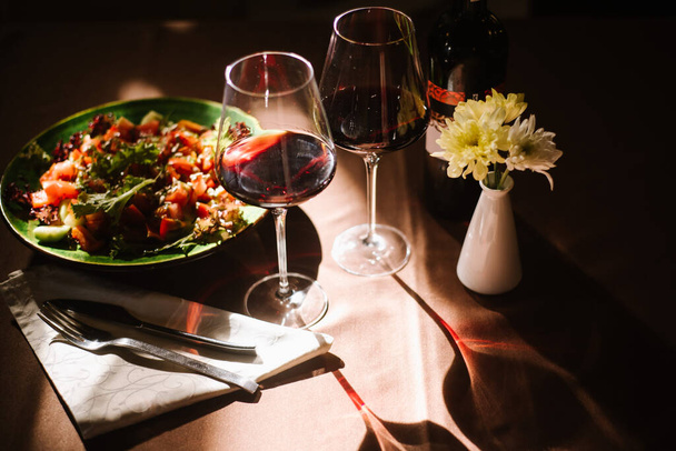 Dvě sklenice s červeným vínem a chutnou snídaní na stole - Fotografie, Obrázek