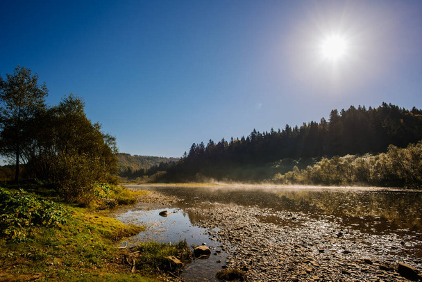 Scenic view of mountain river at the morning with fog on water - Foto, afbeelding
