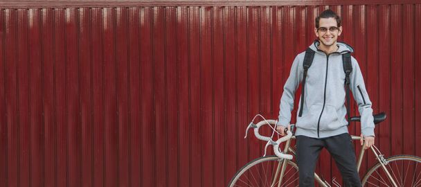 lässiger junger Mann oder jugendlicher Student auf der Straße mit dem Fahrrad im Freien - Foto, Bild