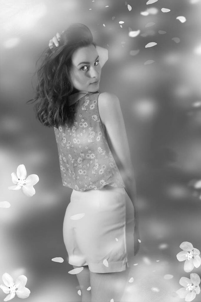 Noir et blanc Portrait d'une superbe jeune brune sexy sur un fond, une blouse fleurie et de courts métrages blancs. Gros plan. Beauté et mode - Photo, image