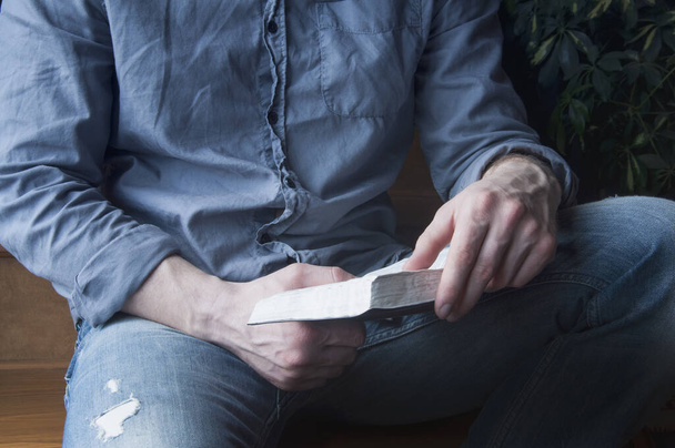 Libro de la Biblia en mano. Un hombre está leyendo la Biblia
. - Foto, imagen