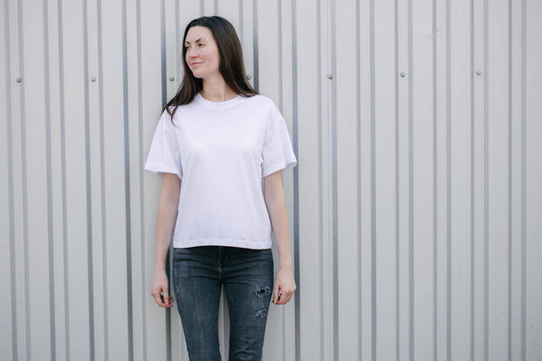 Donna magra con t-shirt bianca e jeans neri con spazio per il tuo logo o design in stile urbano casual su sfondo urbano
 - Foto, immagini