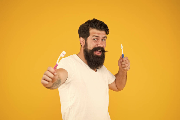 On guard of freshness. Teeth whitening procedure. Bearded man holds toothbrushes yellow background. Hipster happy smiling face cares hygiene. Brush teeth. Fresh breathe. Mint paste. Healthy teeth - Φωτογραφία, εικόνα