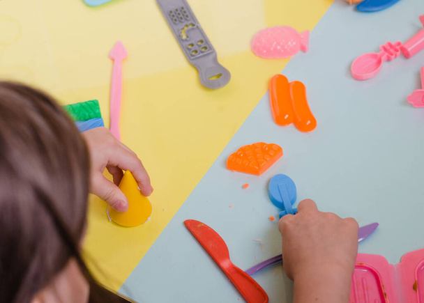 Mãos de criança brincando com argila colorida. Plastina caseira
 - Foto, Imagem