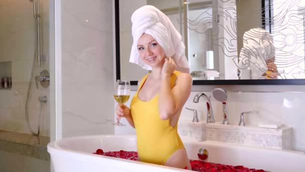 Beautiful Sexy Girl with Glass of White Wine Fun in Bathtub with Red Rose Petals - Πλάνα, βίντεο