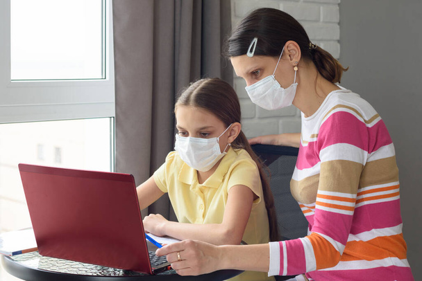 quarantined girl and girl perform school tasks online - Foto, Bild