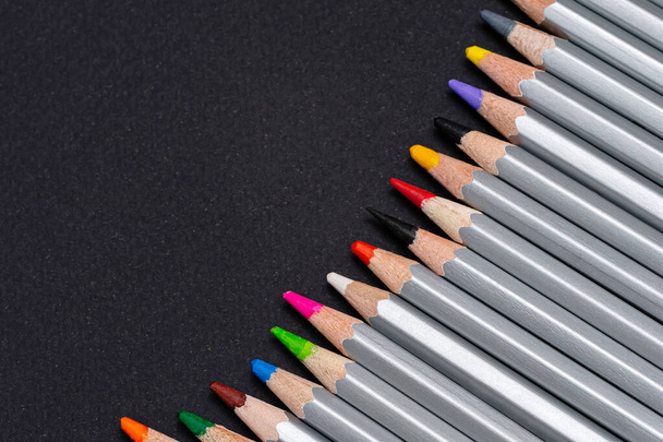 gray wooden pencils with colored rods on a black background - Fotoğraf, Görsel