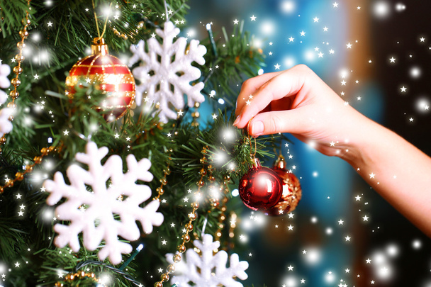Decorating Christmas tree on bright background - 写真・画像