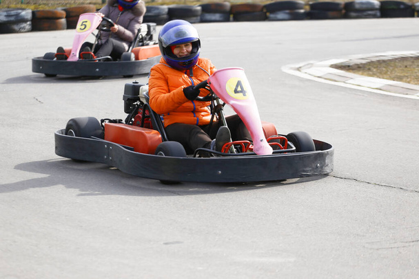 A lány gokart autót vezet sebességgel egy játszótéri versenypályán. Go Kart egy népszerű szabadidős motoros sport. - Fotó, kép