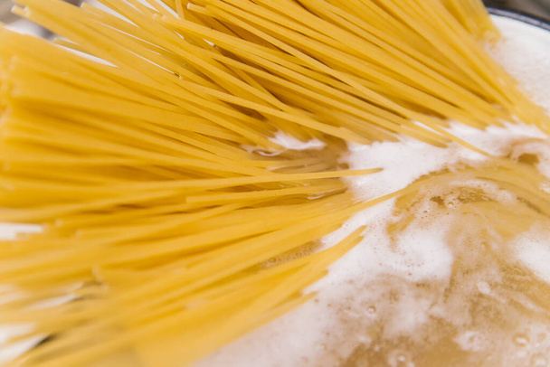 Cooking the pasta . The pasta in the boiling water. Long noodles. Pasta recipes. - Фото, изображение