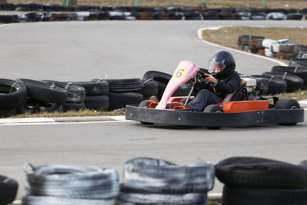 jongen rijdt Go-kart auto met snelheid in een speeltuin racebaan. Go kart is een populaire recreatieve motorsport. - Foto, afbeelding