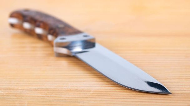 Όμορφο κυνηγετικό μαχαίρι απομονώνονται στο ξύλινο τραπέζι, αντικείμενο - Φωτογραφία, εικόνα