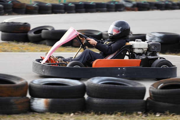 Junge fährt Gokart-Auto mit Geschwindigkeit auf Spielplatz-Rennstrecke. Go-Kart ist ein beliebter Freizeit-Motorsport. - Foto, Bild