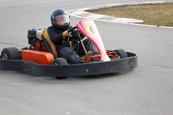 menino está dirigindo Go-kart carro com velocidade em uma pista de corrida playground. Go kart é um esporte a motor de lazer popular
. - Foto, Imagem