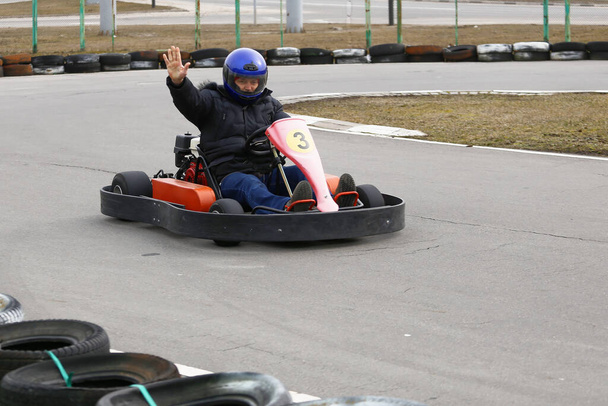boy is driving Go-kart car with speed in a playground racing track. Go kart is a popular leisure motor sports. - Photo, Image