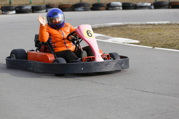 дівчина керує автомобілем Go-card зі швидкістю в ігровому майданчику гоночної доріжки. Go Kart є популярним дозвіллям автоспорту
. - Фото, зображення