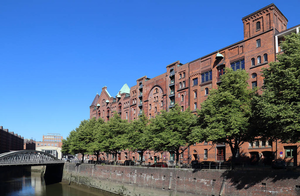 ドイツのハンブルクのSpeicherstadt地区の運河沿いの歴史的倉庫 - 写真・画像