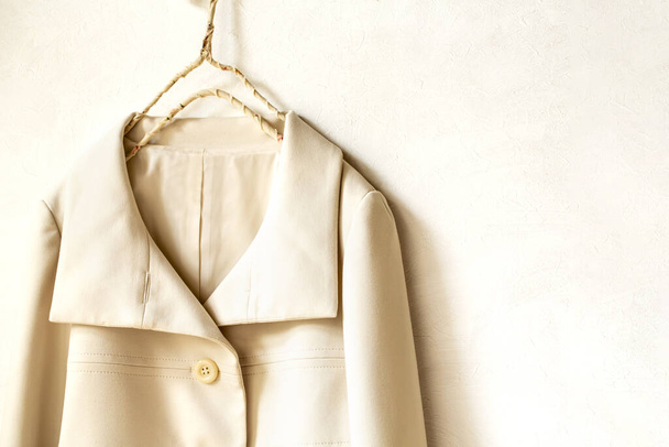 beige or white jacket hanging on clothes hanger on white background.close up. - Fotoğraf, Görsel