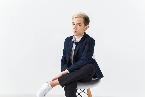 Portrait of stylish school boy teenager in white shirt and jacket against white background. - Zdjęcie, obraz