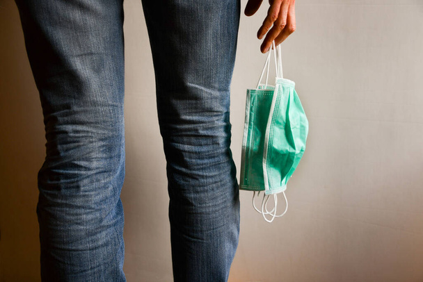 Girl in jeans with three surgical masks hanging in her hand - Photo, Image