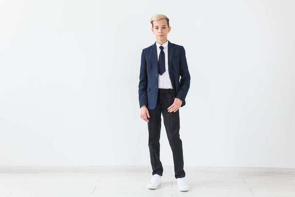 Portrait of stylish school boy teenager in white shirt and jacket against white background. - Φωτογραφία, εικόνα