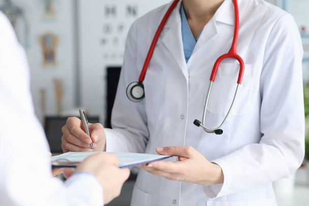 Médica assina cartão de paciente com diagnóstico
 - Foto, Imagem