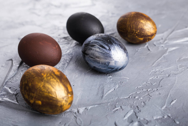 Holidays, traditions and Easter concept - Dark stylish easter eggs on grey background. - Fotografie, Obrázek