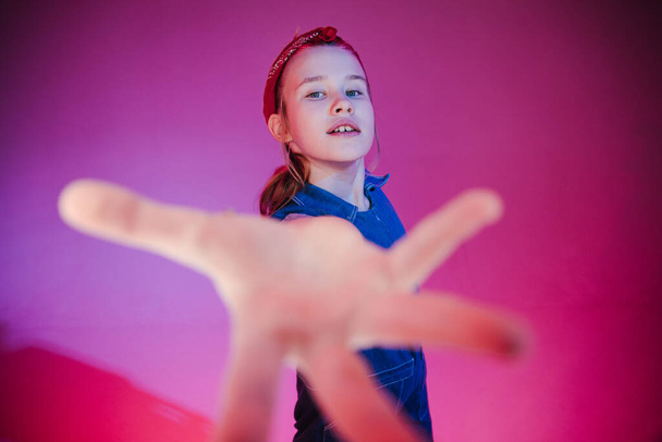 Jong stijlvol meisje in de Studio op een gekleurde neon achtergrond. Muziek dj poster ontwerp. Portret van een jonge danseres. - Foto, afbeelding