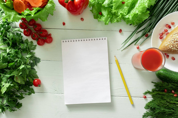 Notebook for keeping a diary of weight loss on the background of vegetables. Drawing up an individual diet. - Foto, afbeelding