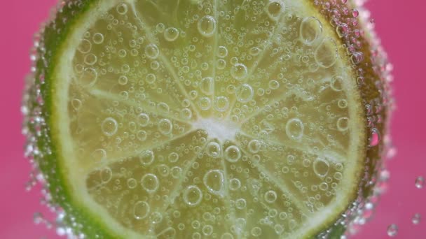 kalkvruchten in water onder water met belletjes. Sappige citrus close-up, macro. selectieve focus. - Video