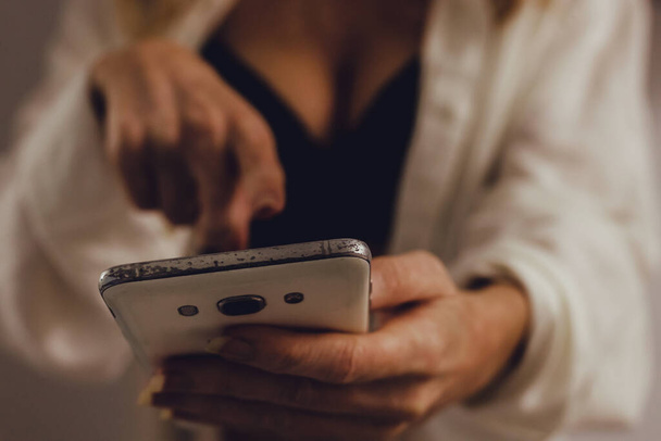 sexy meisje met lingerie en mobiele telefoon of smartphone in de kamer - Foto, afbeelding