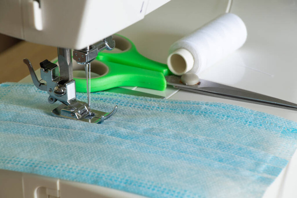 nueva máquina de coser cose una máscara médica durante una pandemia
 - Foto, Imagen