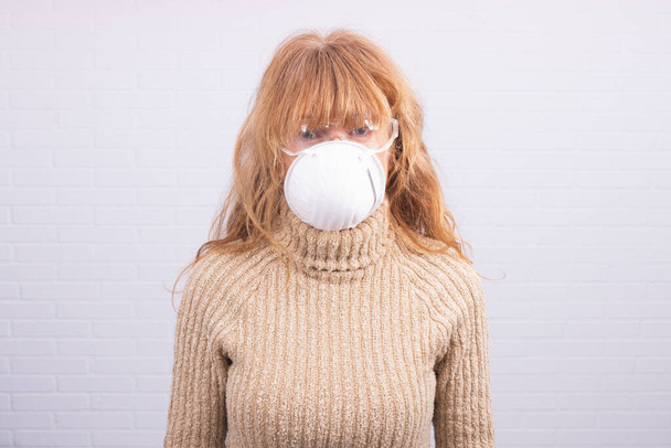 woman with mask on white wall background - Foto, afbeelding