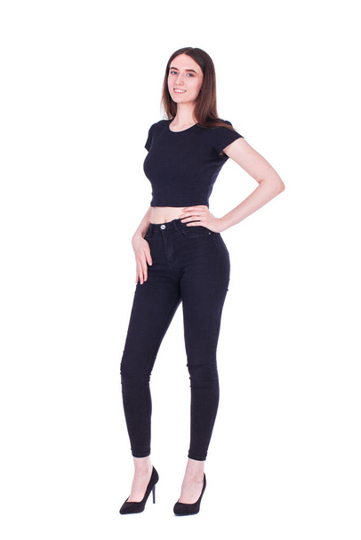 Full body portrait of a young beautiful brunette woman in black jeans, isolated on white background - Valokuva, kuva