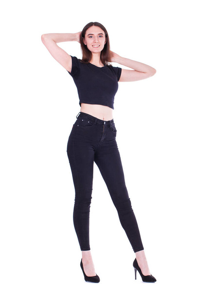 Full body portrait of a young beautiful brunette woman in black jeans, isolated on white background - Fotografie, Obrázek